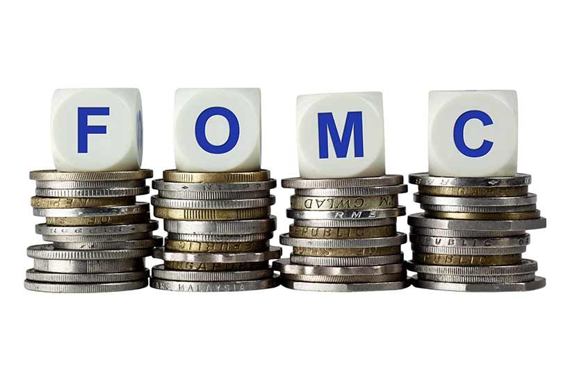 Federal Open Market Committee abbreviation on top of stacks of silver and gold coins