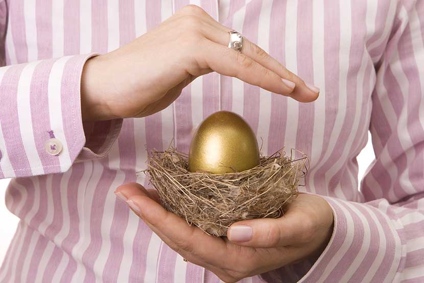 Golden egg in nest protected by hands