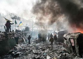 The smoking streets of a war torn Ukraine, citizens and militants walking around in the rubble