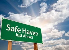 Green safe haven sign with sun breaking through clouds in the background