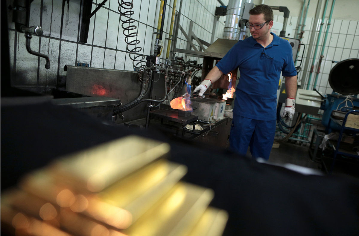 Man pouring liquid gold into bars