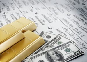 Bars of gold and three stacks of $100 and $50 bills atop an alphabetized list of stocks