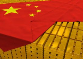 Massive expansive of stacked gold bars peeking out from under Chinese flag, draped over them