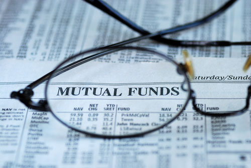 Mutual funds section of newspaper with pair of eyeglasses magnifying the newspaper heading
