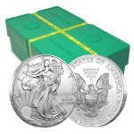 front and back of silver american eagle coin in front of green hox with yellow tape