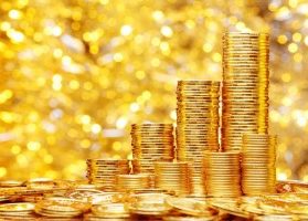 Gold coins stacked against a glittering gold backdrop