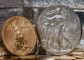 American Gold Eagle Coin next to Silver Eagle Coin, against a backdrop of silver bars
