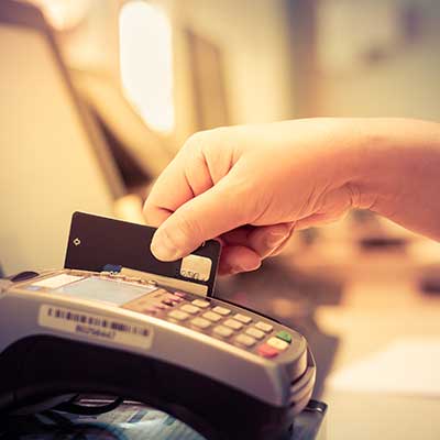 hand swiping credit card through credit card machine