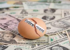 Broken egg that says, "Retirement" on top of U.S. dollar bills