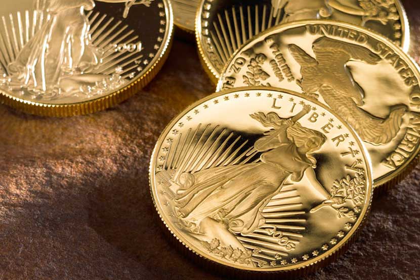 Proof Gold American Eagles displayed on wooden table