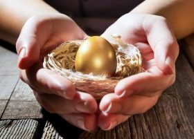 Hands holding nest with golden egg inside