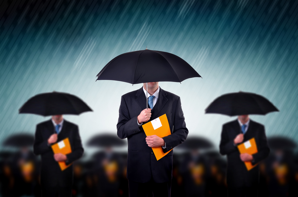 Businessmen with umbrella standing in stormy rain.