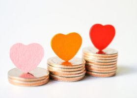 Stacks of gold and silver coin gifts, with various felt hearts sitting on top