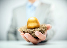 Businessman holding out nest with golden egg