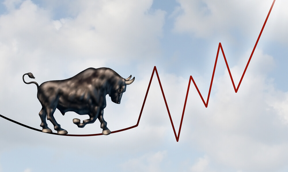 Bull market risk financial concept with bull walking on tight rope