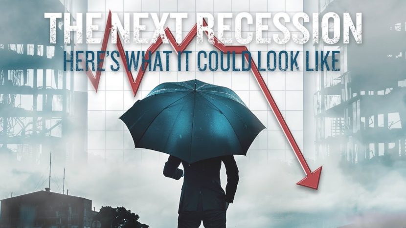 businessman holding umbrella to protect himself from the next recession as shown by red downward arrow