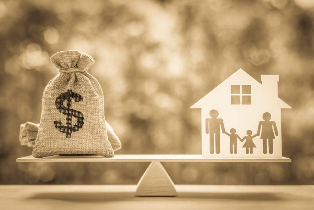 Bag of cash balancing house illustration with family of four cutout