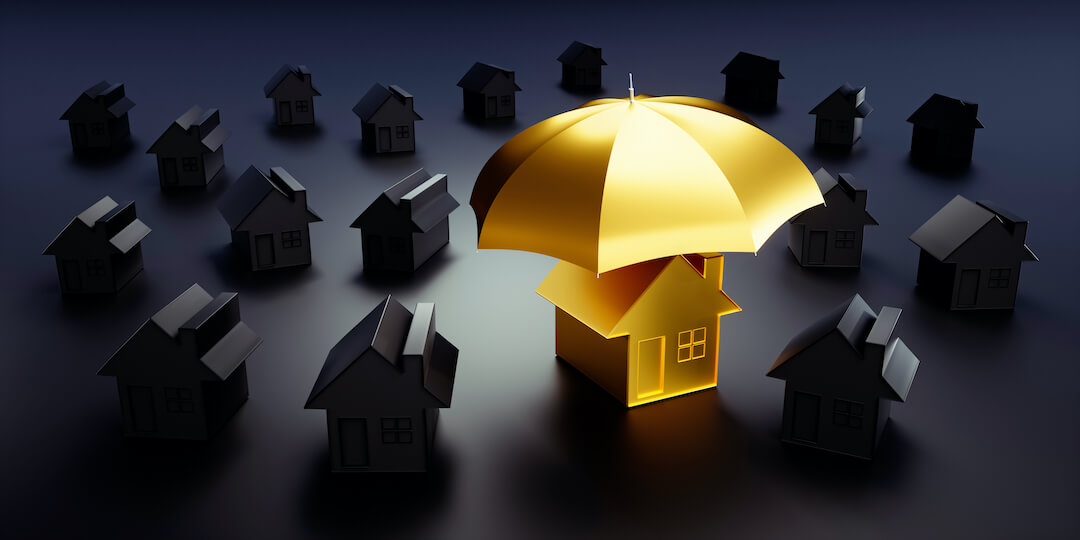 Gold umbrella over house surrounded by other houses in darkness