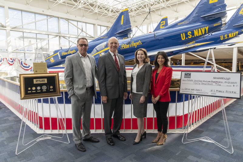 Naval Aviation Museum Foundation donation presentation of check and commemorative coins in front of Blue Angels planes