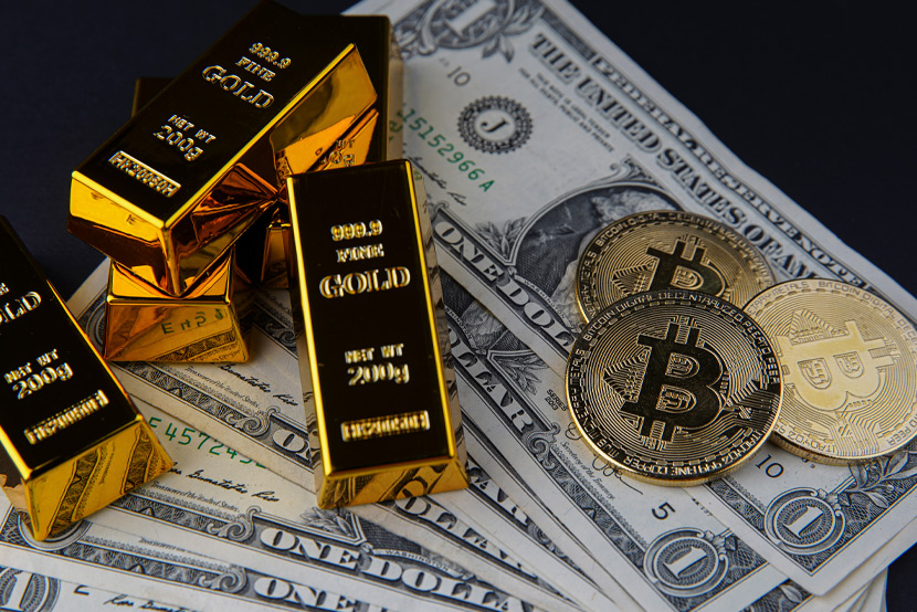 Gold bars and bitcoins sitting on top of dollars