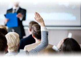 Woman raising hand during seminar