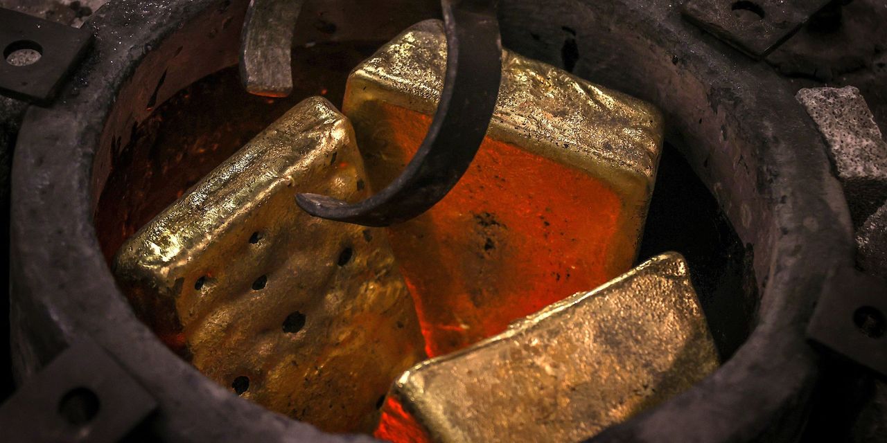 Gold bullion grabbed by tongs from a cauldron.