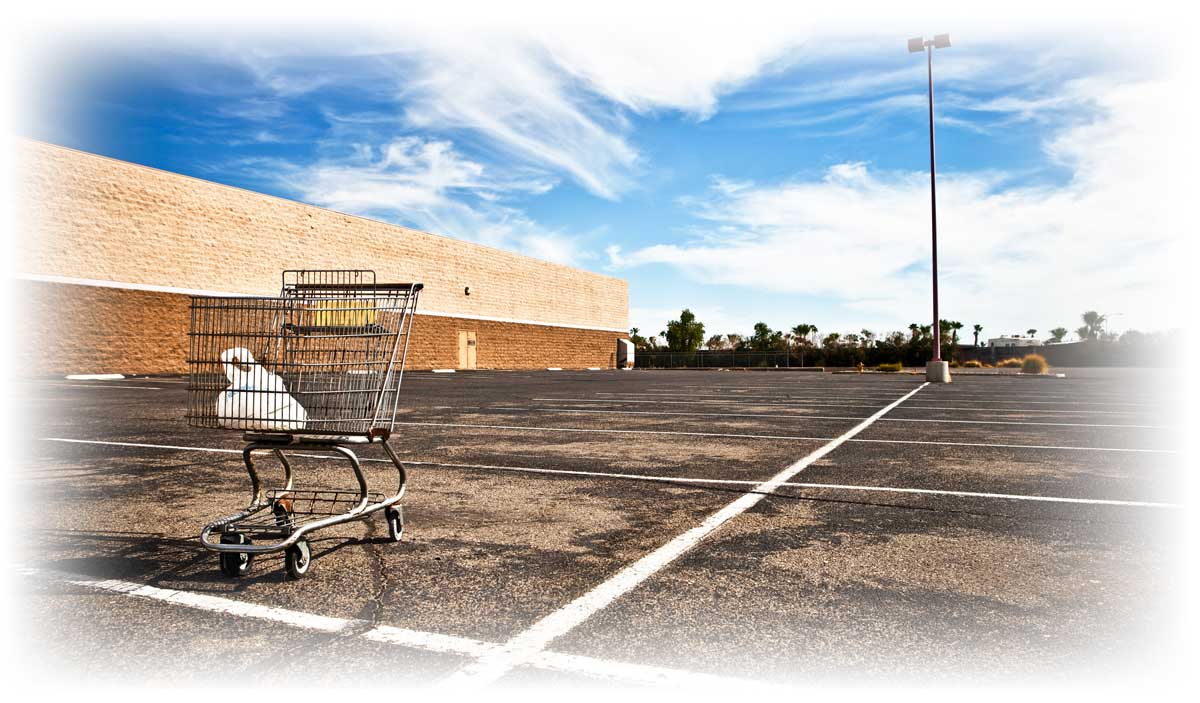 Single shopping cart in empty parking lot