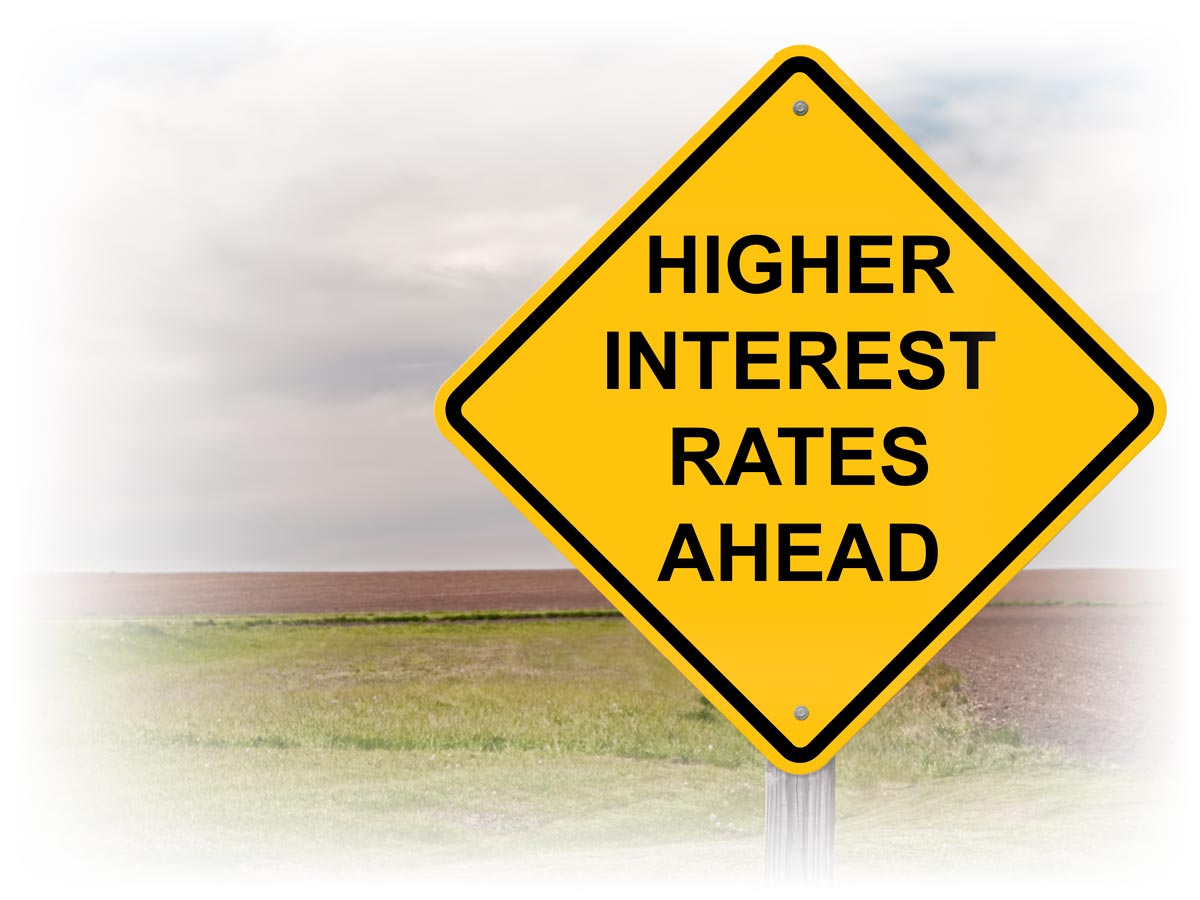 Road sign reading “HIGHER INTEREST RATES AHEAD”