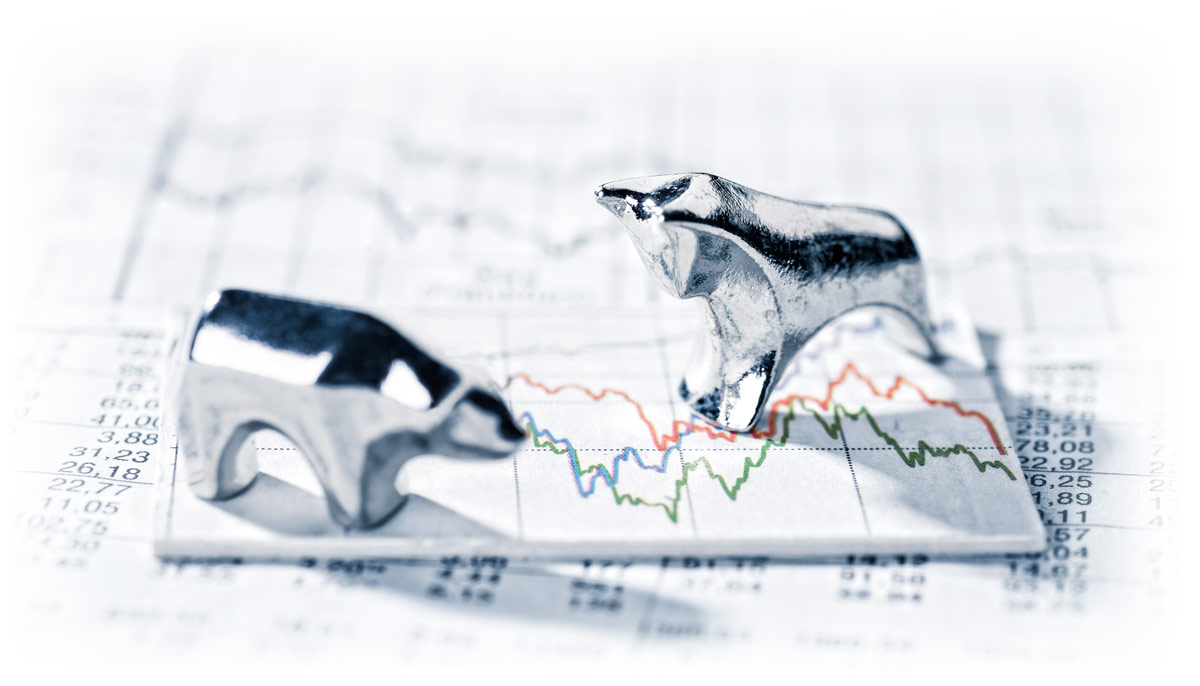 Silver bull and bear on top of market charts showing volatility