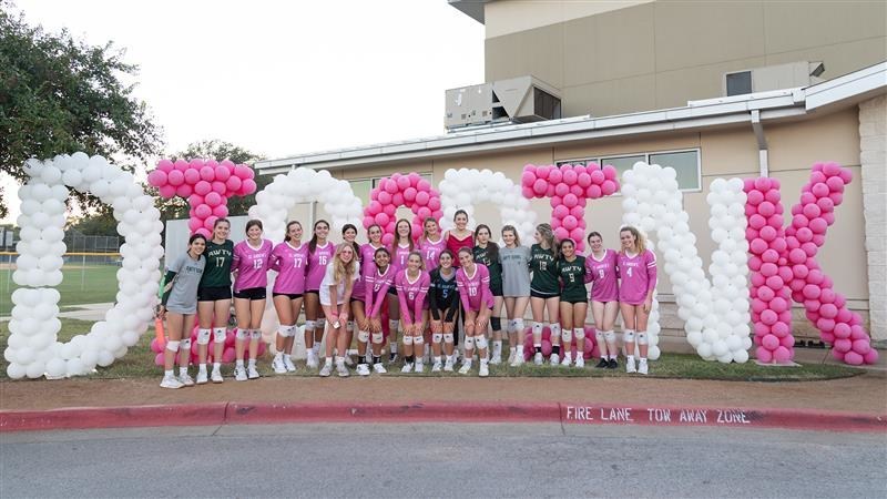 Molly Phillips poses with the volleyball teams. Photo by Cambry Thompson.
