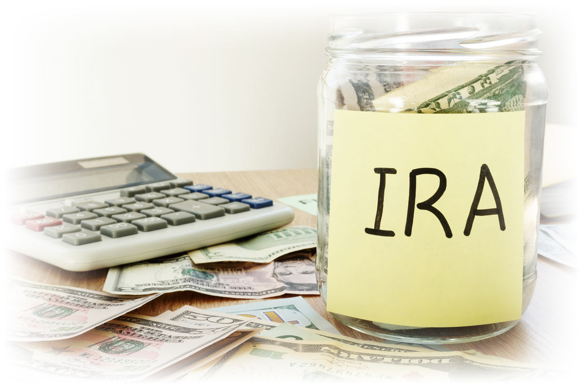 Calculator and loose cash beside jar filled with cash labeled "IRA"