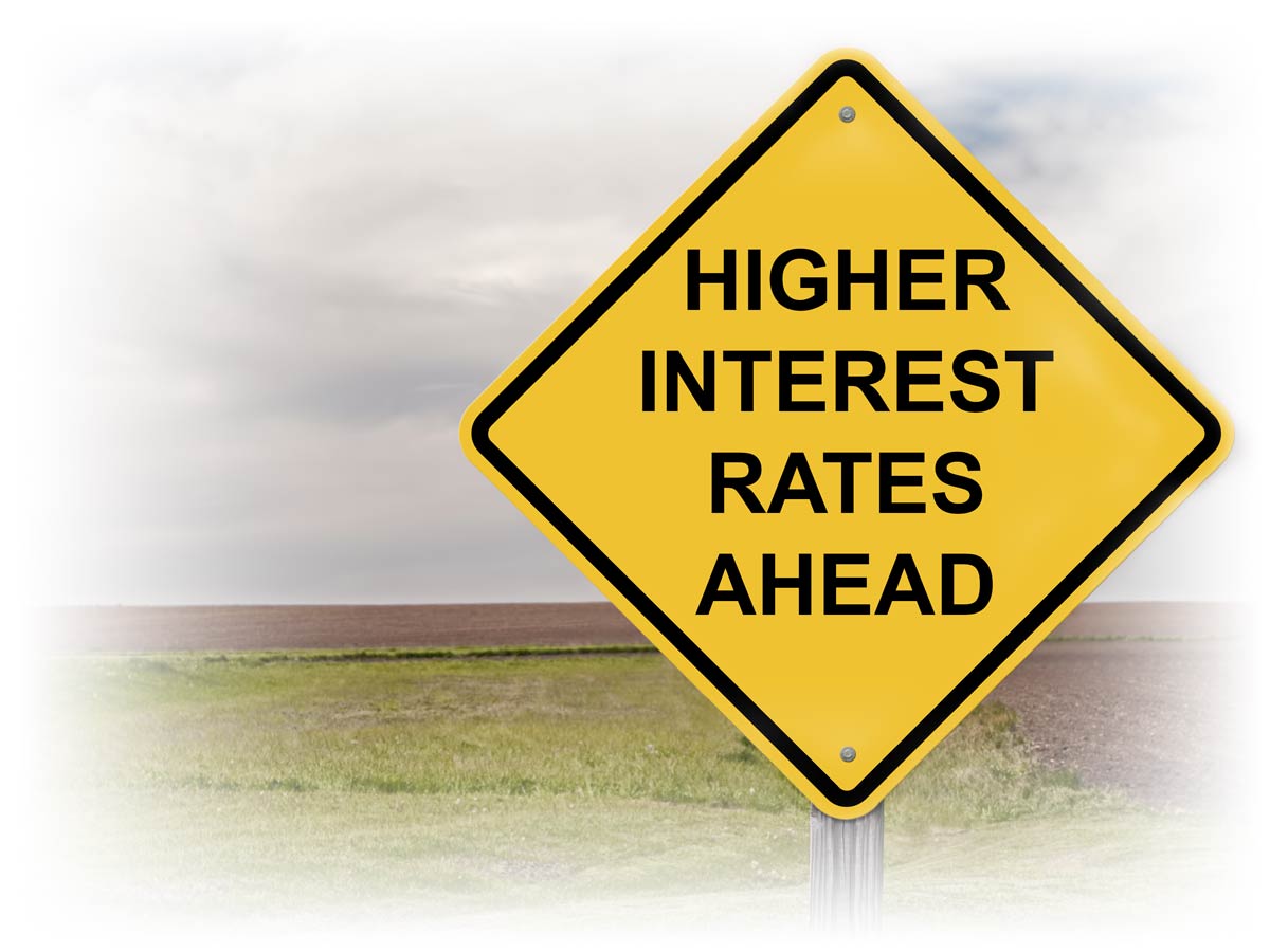 Road sign reading "HIGHER INTEREST RATES AHEAD"