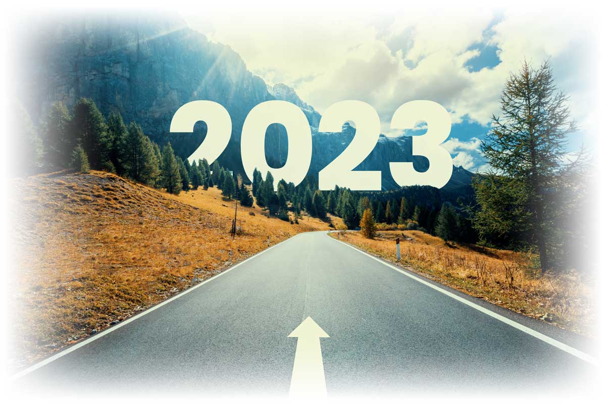White arrow on road leading into mountains with "2023" overhead