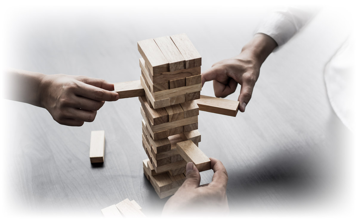Business people removing blocks from a stacking game