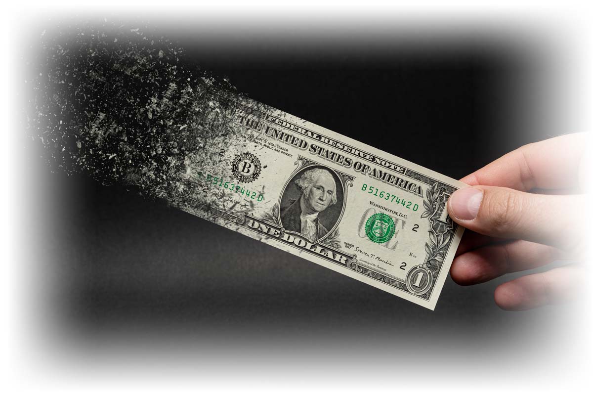 Hand holding dollar bill as it disintegrates