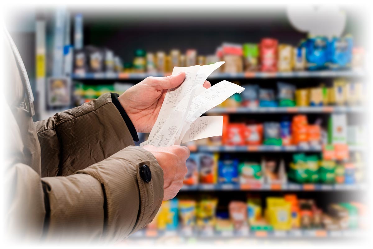 Hands holding receipts in grocery aisle