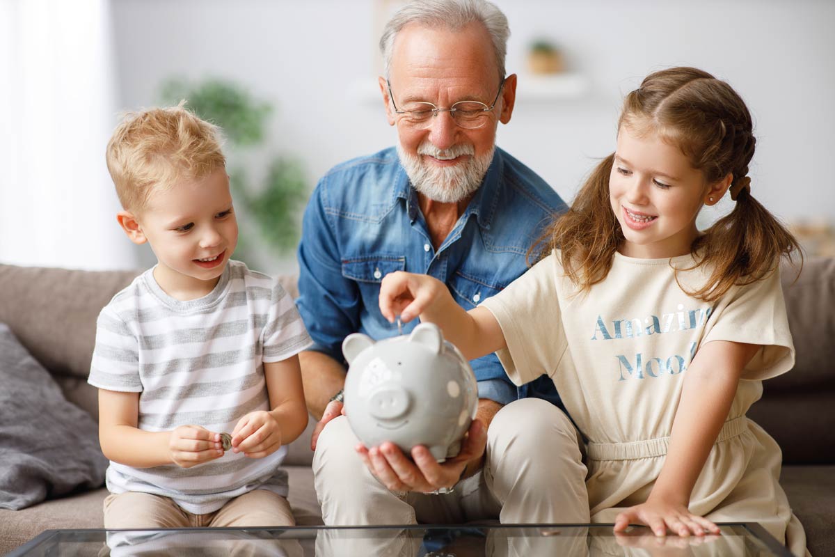 Older man with grandchildren and piggy bank