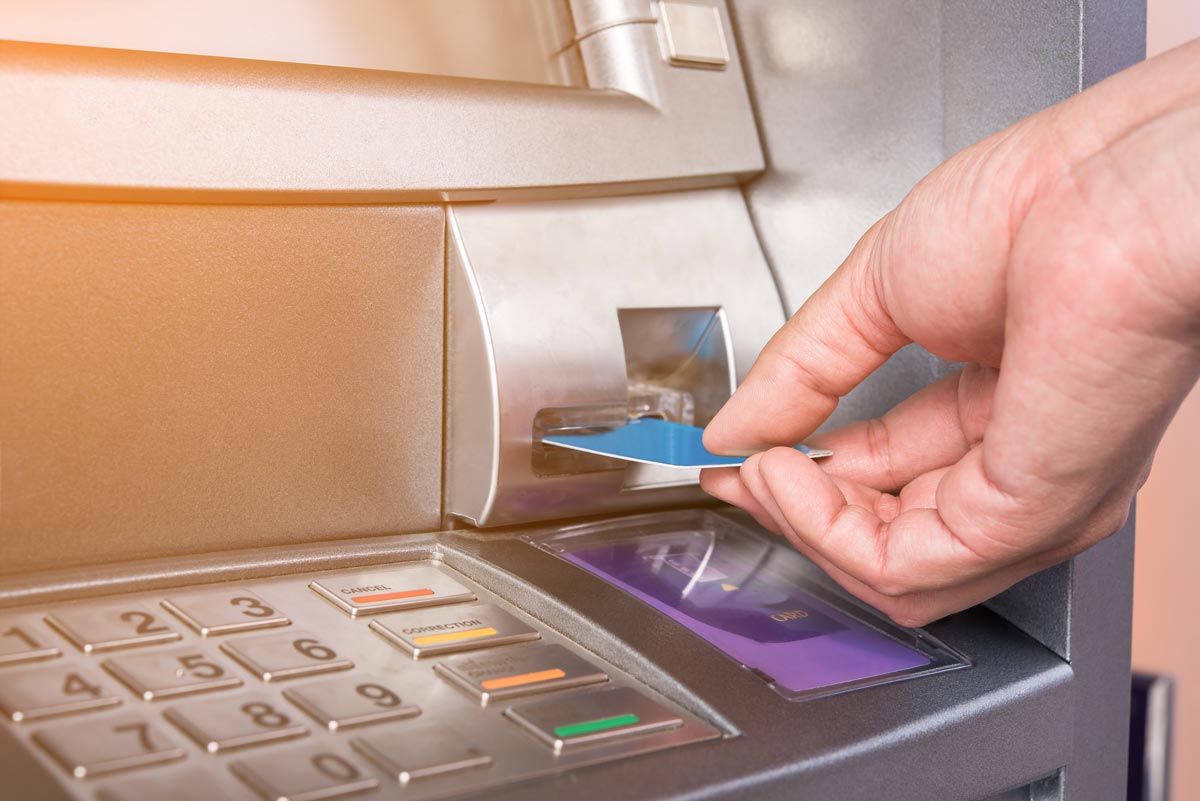 Hand inserting card into ATM