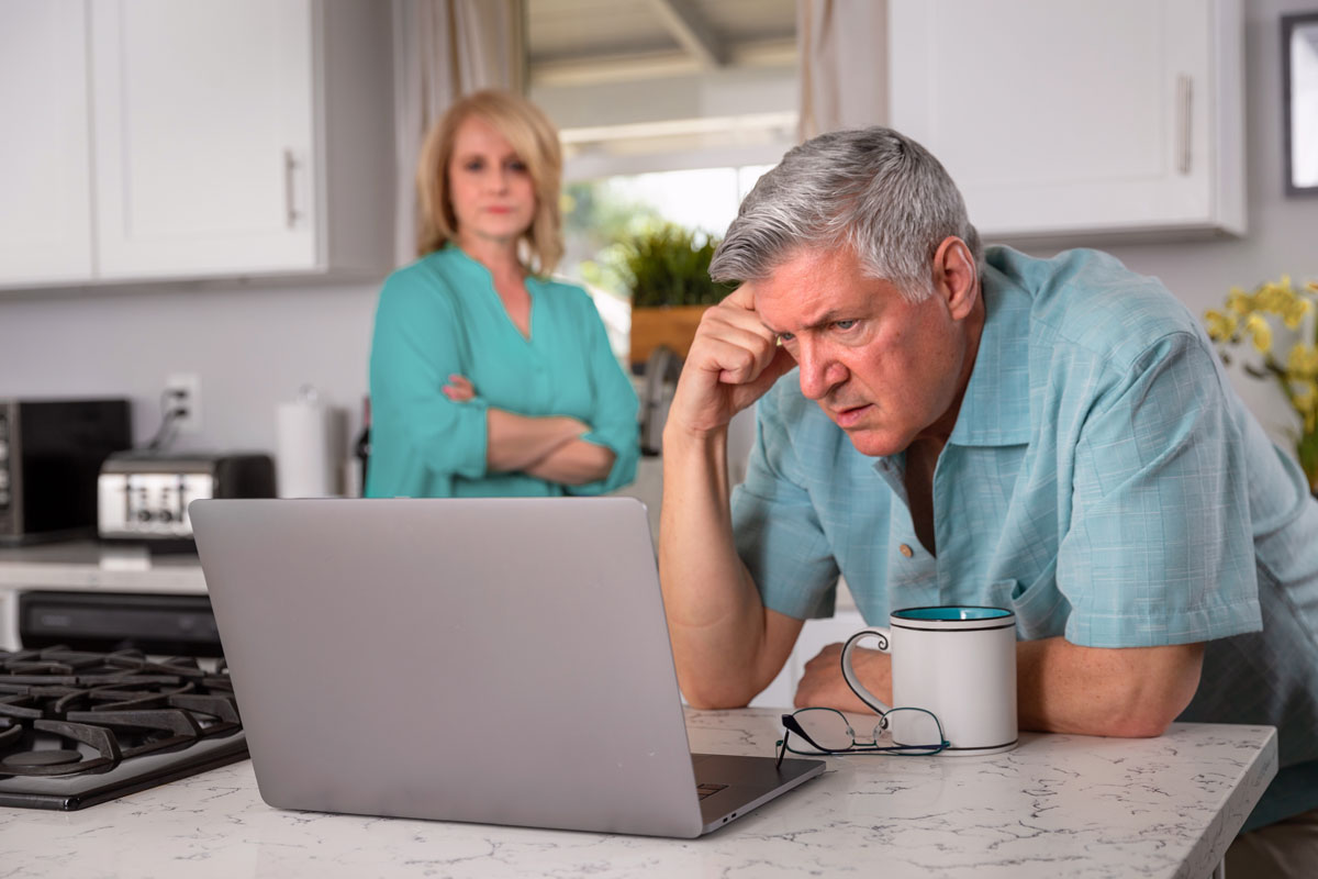 Stressed older couple looking at laptop