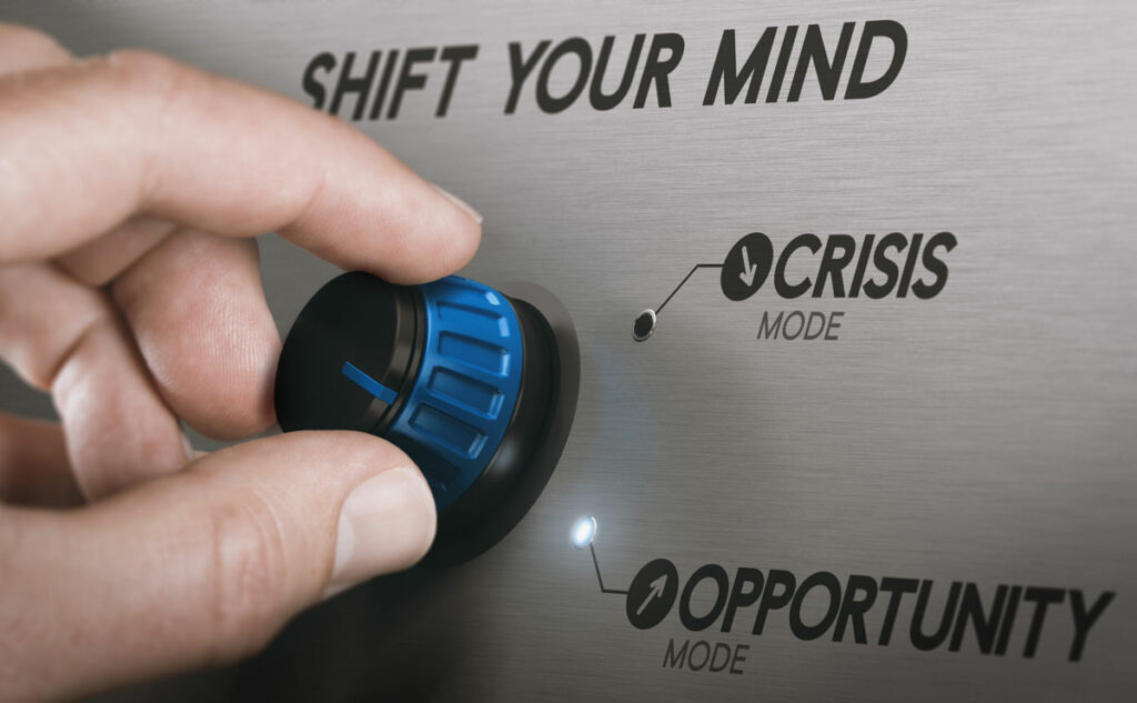 Hand turning knob from "Crisis Mode" to "Opportunity Mode"