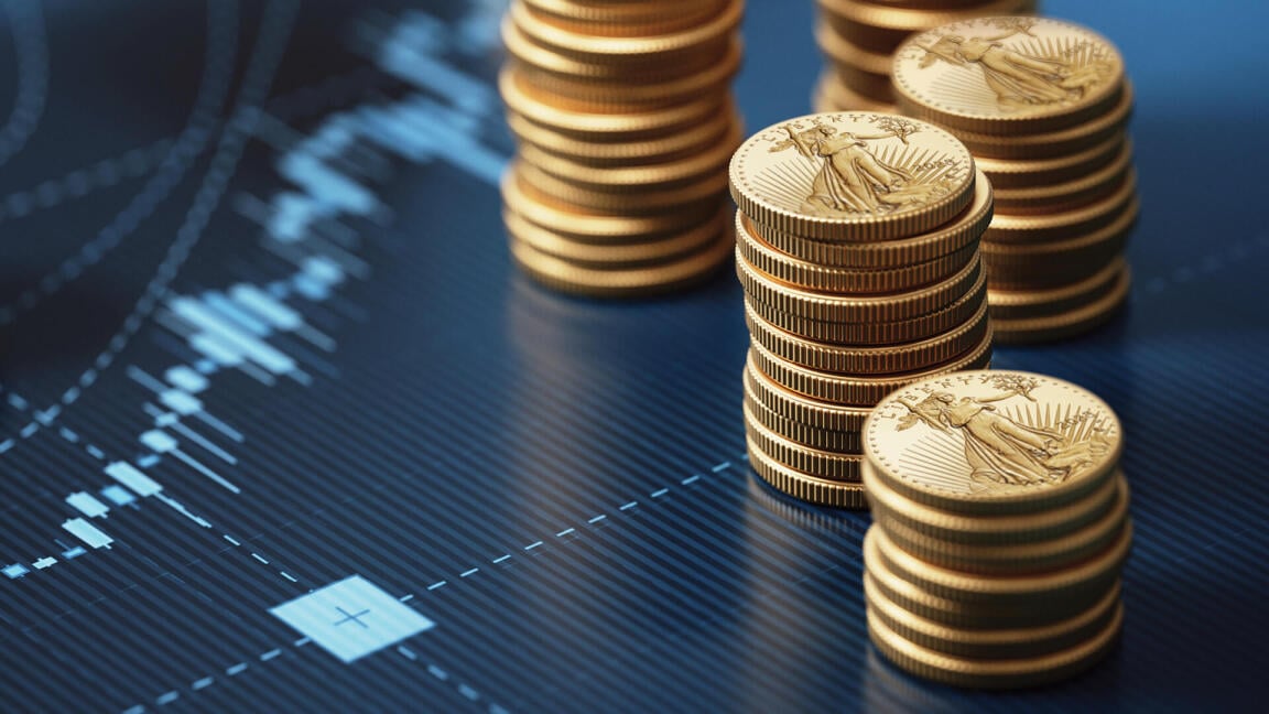 Stack of gold coins on blue chart